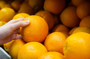 Woman is choosing orange in the supermarket