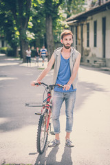 young hipster gay man with bike