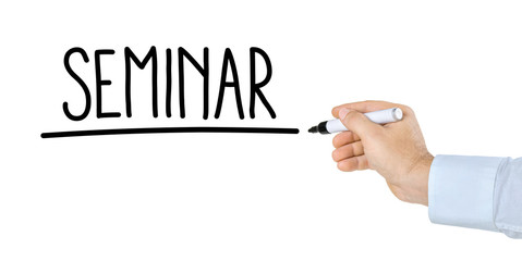 Hand mit Stift schreibt Seminar