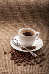 cup of coffee, grains on burlap tablecloth