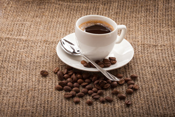 cup of coffee, grains on burlap tablecloth