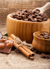 coffee beans in wooden bowl and chocolate on burlap tablecloth