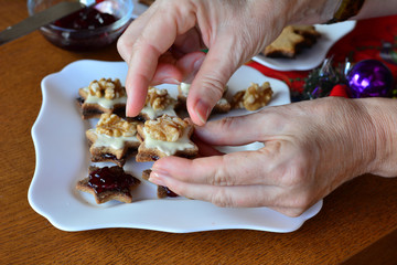 Woman is decorating cookies for Christmas