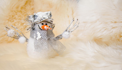 Christmas toy snowman on white sheep fur background
