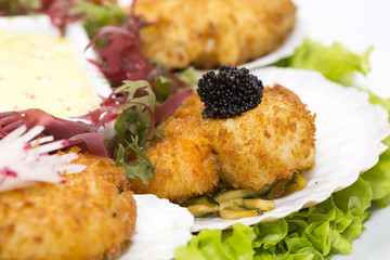 fried scallops decorated with caviar and greens