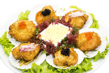 fried scallops decorated with caviar and greens