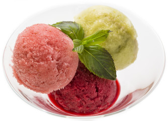 several fruit balls of sweet sorbet in a glass