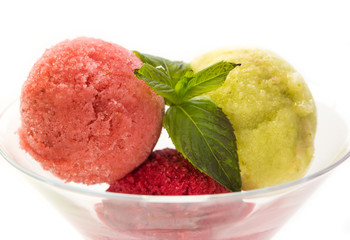 several fruit balls of sweet sorbet in a glass