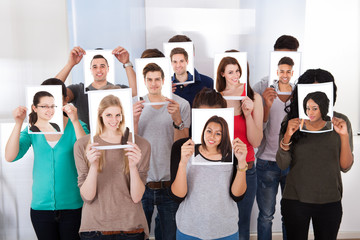 Fototapeta premium College Students Holding Photographs In Front Of Faces