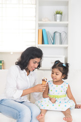 indian mother and child enjoying ice cream indoor
