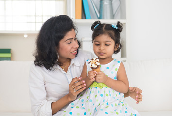 indian mother and child enjoying ice cream indoor