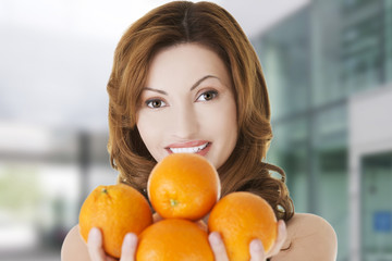 Woman holding group of oranges