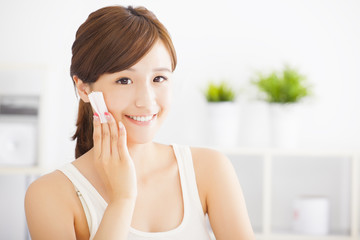 Beautiful asian young woman cleaning her face with cotton