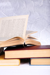 Books on wooden table on light background