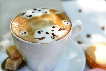 Cup of coffee with cute drawing on table, close up
