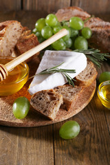 Camembert cheese, bread, honey and grapes