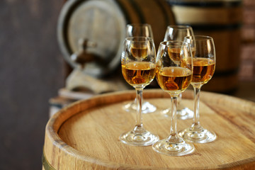 Glasses of wine in cellar with old barrels