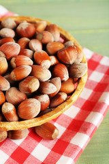 Hazelnuts on wicker mat on wooden background