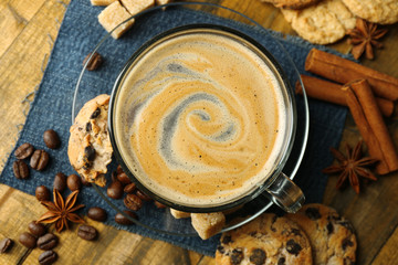 Cup of coffee and chocolate chip cookies on wooden background
