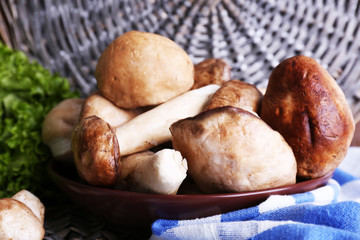 Wild mushrooms on plate with herbs and greens on table