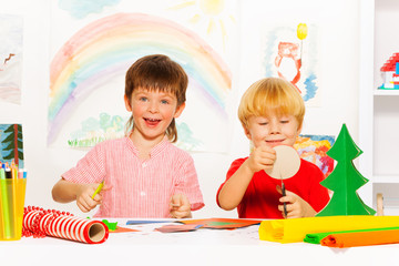 Fototapeta premium Happy boys make Xmas decorations with scissors