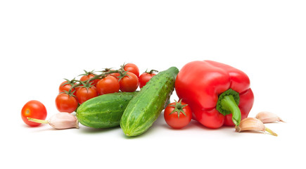 red peppers, garlic, cherry tomatoes and cucumbers on a white b