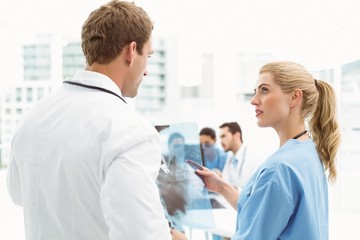 Obraz premium Male and female doctors examining x-ray