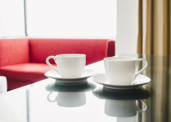 Two cup of coffees with sofa room interior