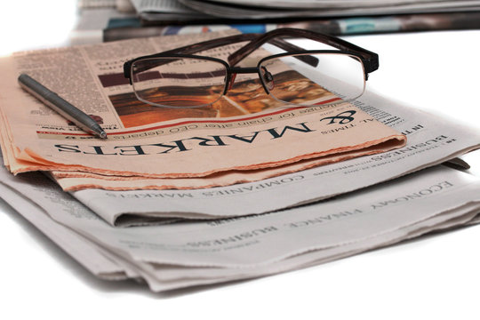 Glasses on the newspaper. Articles about markets.
