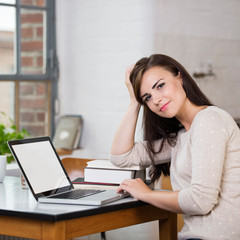 sympathische junge frau arbeitet zuhause am laptop