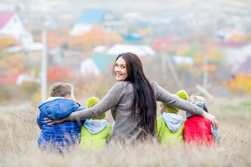 Happy mother with small children walking