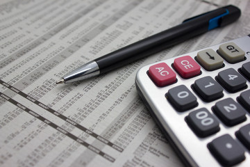 Business background with calculator and pen.