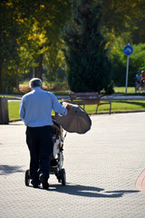 abuelo paseando con un carrito de niño
