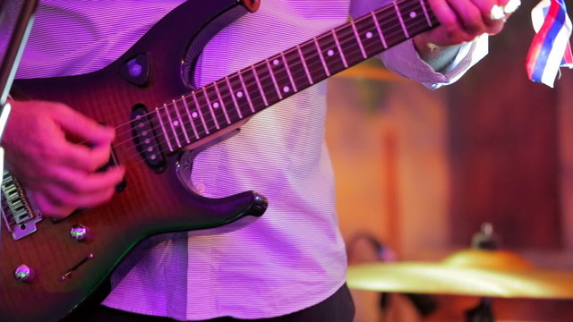 Close-up shot. Man Playing Guitar at Concert.