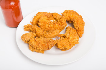 Chicken Strips on White Plate with Hot Sauce on Side