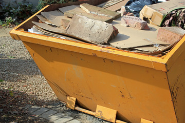 Close-up of yellow skip full of concrete and rubbish