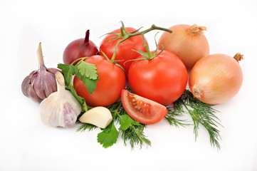 still life from tomatoes onions and garlic with greens on a whit
