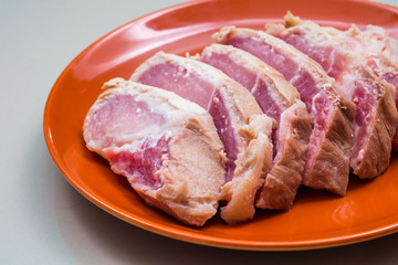 Raw sliced pork in the orange dish - Ingredient