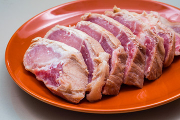 Raw sliced pork in the orange dish - Ingredient