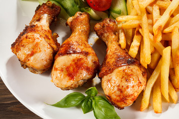 Grilled chicken legs with chips and vegetables