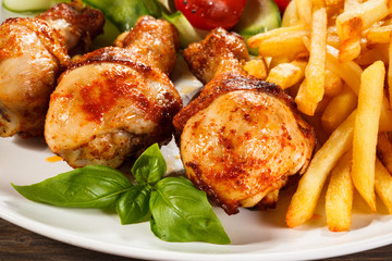 Grilled chicken legs with chips and vegetables