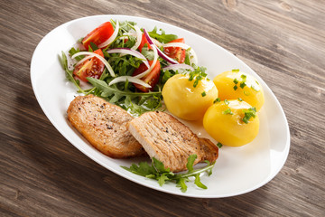 Fried steaks, boiled potatoes and vegetable salad