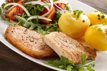 Fried steaks, boiled potatoes and vegetable salad