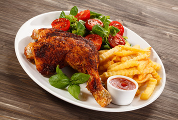 Grilled chicken legs with chips and vegetables