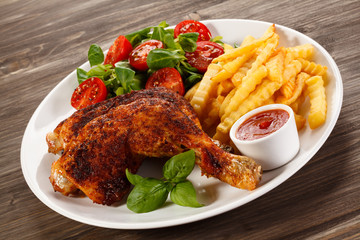 Grilled chicken legs with chips and vegetables