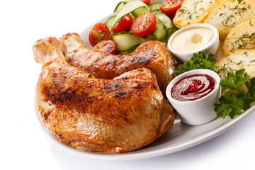 Barbecued chicken legs with baked potatoes and vegetables