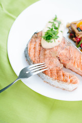 Grilled Salmon with Fresh vegetables on green background