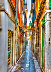 Fototapeta premium Wąska kamienna ulica w Wenecji we Włoszech. Przetworzono HDR