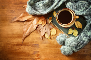 Top view of Cup of black coffee with autumn leaves, a warm scarf