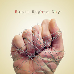 man hand tied with wire and the text human rights day